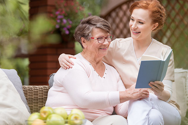 older woman and younger woman reading a book together